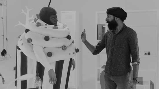 Sandeep directing an actor dressed in a full cupcake costume