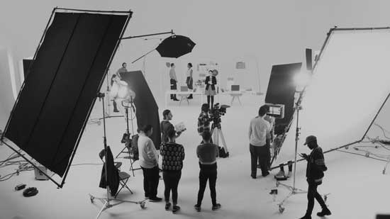 Wide shot of the set with huge lights and flags